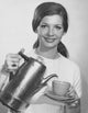 Portrait of a young woman pouring tea from a kettle poster print.