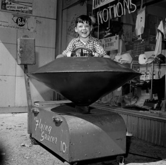 Boy in Toy Ride Outside Store Poster Print
