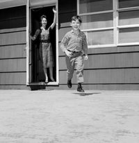 Boy running in backyard poster print featuring a joyful child and mother waving.