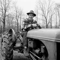 Man Driving Tractor Poster Print showcasing rural life.