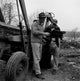 Two men standing by tractor discussing plans poster print