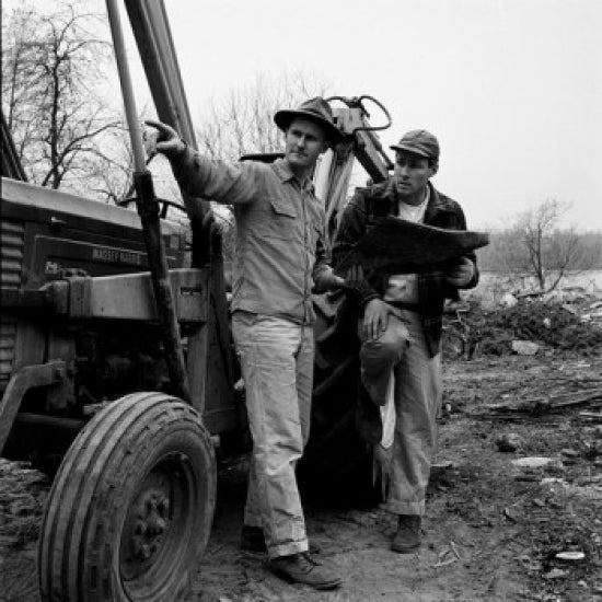 Poster print of two men standing by a tractor discussing plans