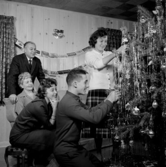 Family preparing Christmas tree in living room poster print