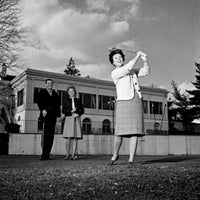Mature woman playing golf while spectators watch - Poster Print