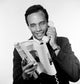 Portrait of African American man holding receiver and reading magazine in a studio shot.