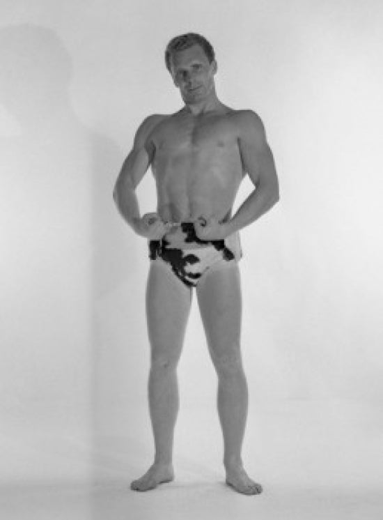 Poster print of a muscular man wearing animal print trunks in a studio shot.