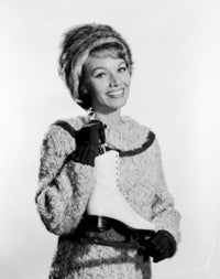 Portrait of a young woman gracefully holding an ice skate.
