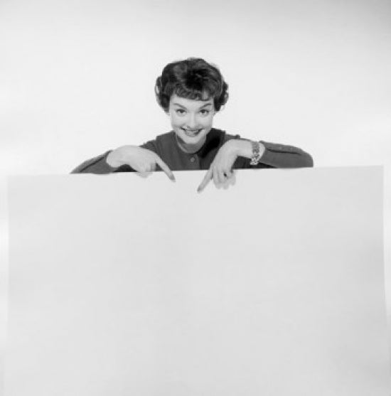 Portrait of a young woman pointing to a blank placard poster print.