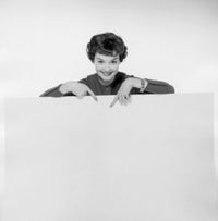 Portrait of a young woman pointing to a blank placard poster print.