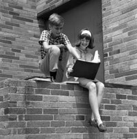 Children Reading Outside Poster Print showcasing a serene outdoor scene.