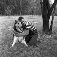 Boy Embracing Dog on Grass Poster Print