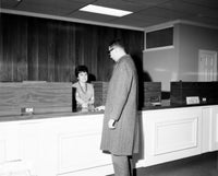 Man at Hotel Reception Desk Poster Print showcasing elegance and hospitality.