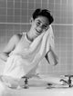 Smiling boy drying his face with towel in bathroom poster print