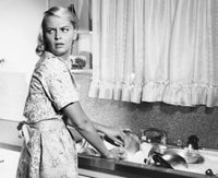 Young woman washing dishes in cozy kitchen poster print