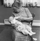 Grandmother Feeding Baby Poster Print showcasing a tender moment of love.