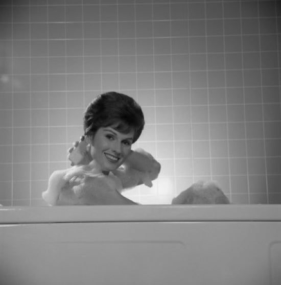 Portrait of a young woman relaxing in a bath poster print.