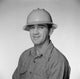 Portrait of a mid adult man wearing a hard hat, showcasing determination and professionalism.