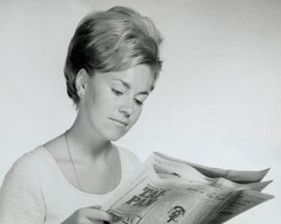 Close-up poster print of a young woman reading a newspaper, showcasing elegance and curiosity.