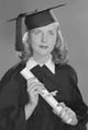 Studio portrait of female graduate holding diploma poster print.
