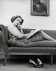 Portrait of a young woman sitting on a chaise longue poster print.