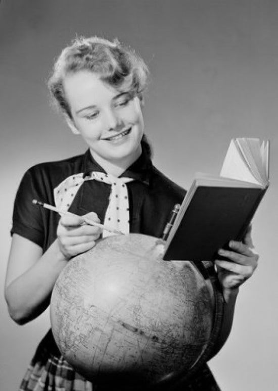 Girl reading a book next to a globe - poster print