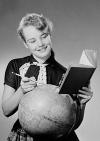 Girl reading a book next to a globe - poster print