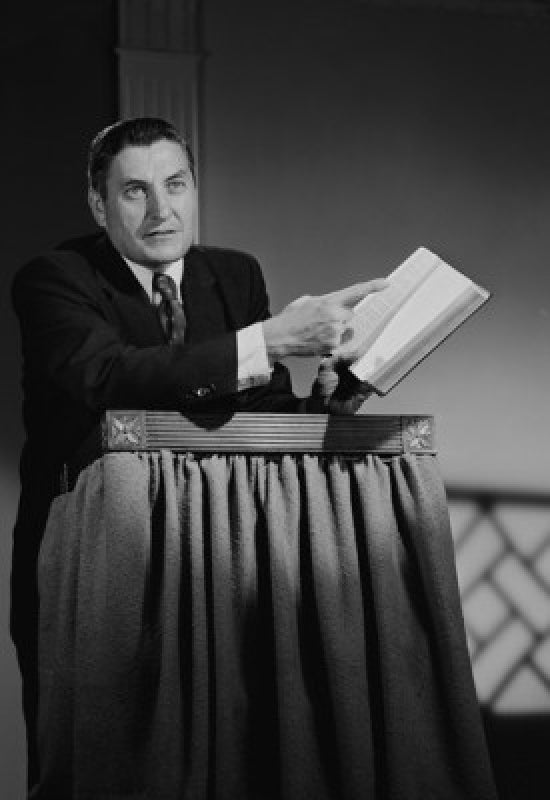 Preacher at lectern pointing at book poster print