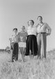 Parents with children standing in a beautiful meadow poster print.