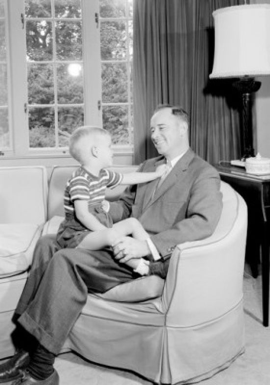 Boy sitting on father's lap poster print, capturing a heartwarming family moment.