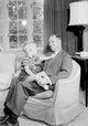 Boy sitting on father's lap poster print, capturing a heartwarming family moment.