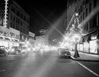 Night view of shopping center with electric Christmas decorations poster print.