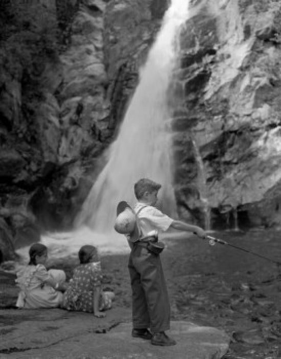 Boy fishing and girls sitting by a beautiful waterfall poster print