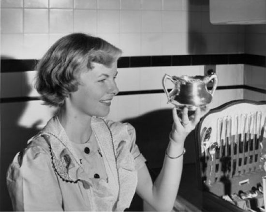 Close-up poster print of a young woman looking at a silver art piece.