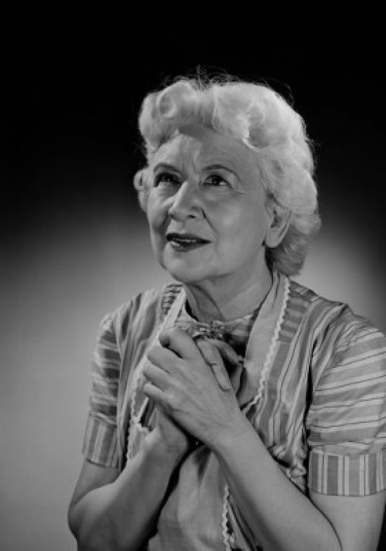 Portrait of a praying senior woman studio shot poster print