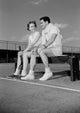 Young couple sitting by tennis court poster print