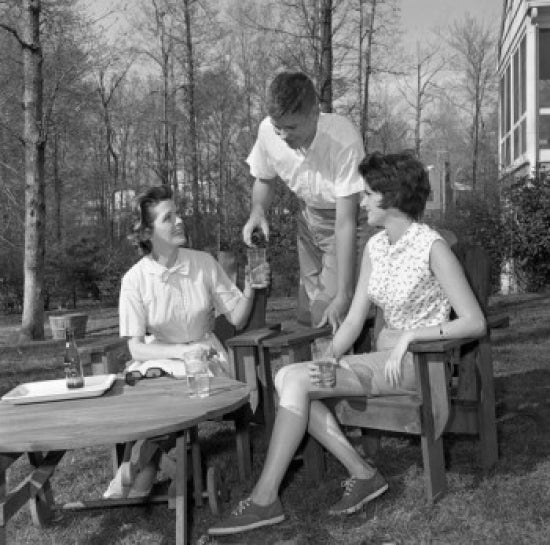 Young couple relaxing in backyard, drinking water poster print