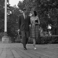 Young Couple Walking on Sidewalk Poster Print showcasing romance and companionship.