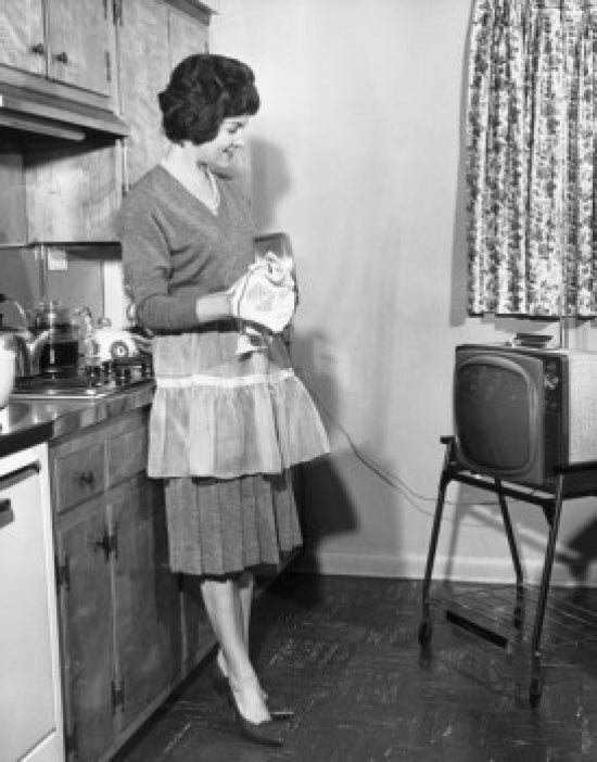 Contemplative young woman side profile looking at television in kitchen poster print.