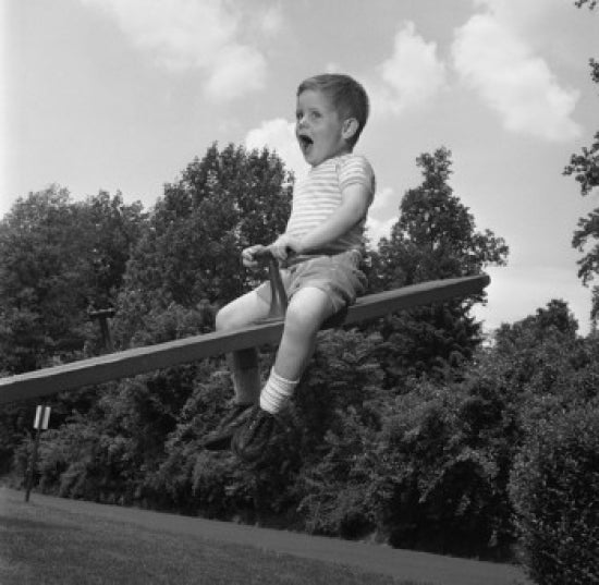 Colorful poster print of a boy sitting on a seesaw and shouting.