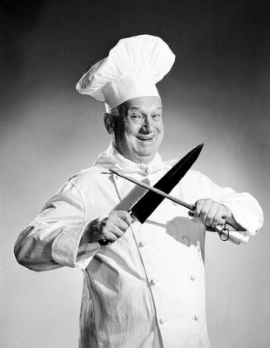 Studio portrait of a chef sharpening a knife art print.