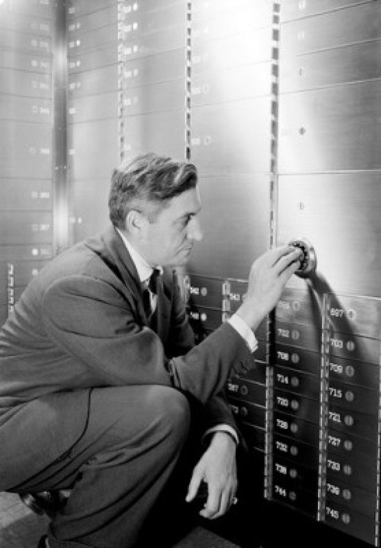 Man Opening Safe in Bank Poster Print showcasing suspenseful moment.