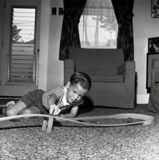 Boy playing with a toy car on the floor poster print