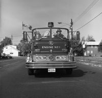 Fire Engine on Road Poster Print showcasing a vibrant fire truck in motion.