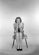 Portrait of a young woman sitting on a stool, elegant poster print.