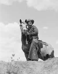 Cowboy on Top of Escarpment Poster Print showcasing a lone cowboy on a cliff.