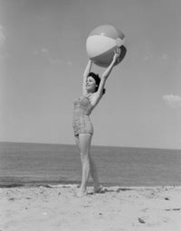 Young woman in swimwear holding beach ball poster print.