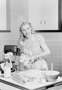 Young woman cooking in kitchen poster print
