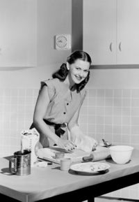 Young woman baking a cake in a cozy kitchen - Poster Print