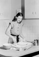 Young woman preparing cake in a cozy domestic kitchen poster print.