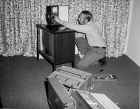 TV Repairman at Work Poster Print showcasing classic television nostalgia.